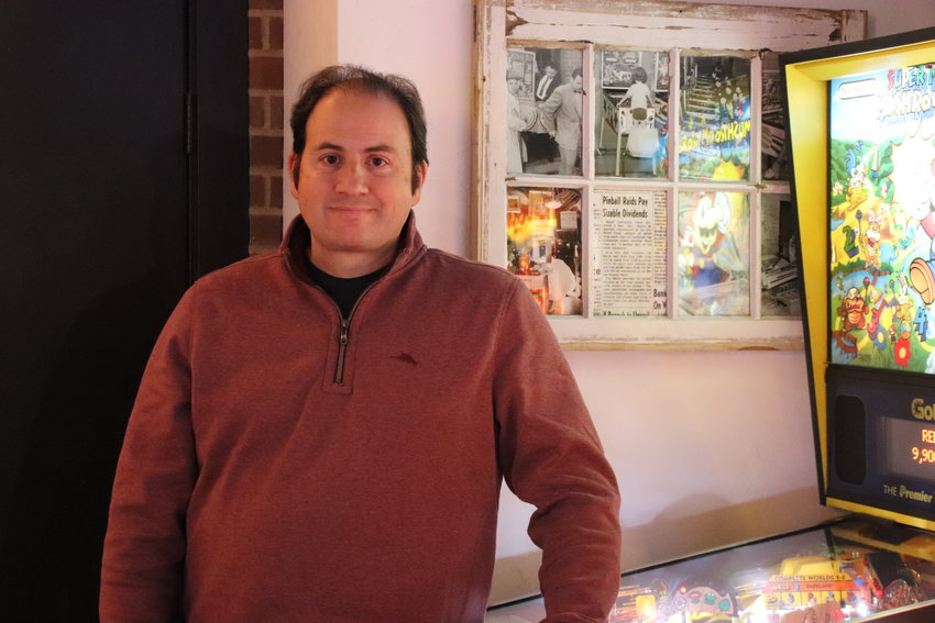 Colorado Pinball Pub owner Dan Nikolich poses with the oldest pinball machine in the pub, from 1981. On top of more than 20 pinball games, the Littleton pub also offers a vast selection of whiskey.