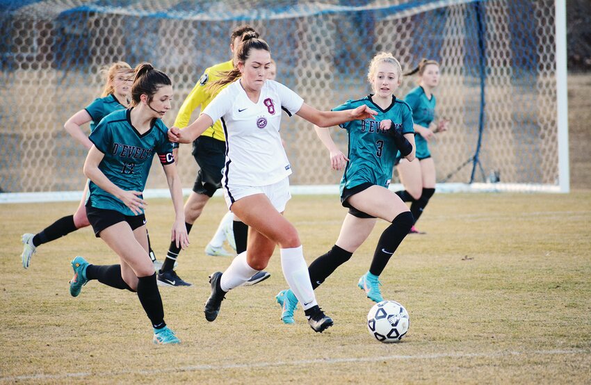 Chatfield senior Emmy Kercher (8) is bracketed by D’Evelyn junior Camille Kollar, left, and freshman Elliot McSimin during the first half March 13 at Lakewood Memorial Field. Chatfield picked up its second victory of the season with a 2-0 victory over D’Evelyn.