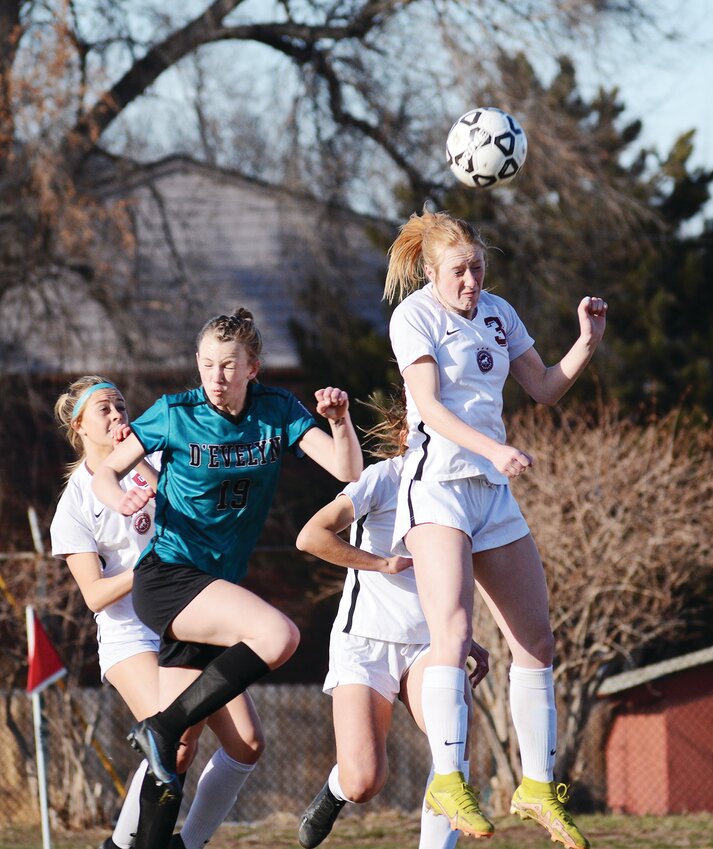 Chatfield sophomore Kyra Kuennen (3) gets up for a header in front of D’Evelyn freshman Clayton Lawrence during the non-league game March 13 at Lakewood Memorial Field. The Chargers got a pair of second-half goals to take a 2-0 victory over D’Evelyn.