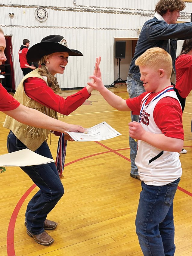 Elizabeth Stampede Rodeo Queen Kyra Doud high-fives #1 Austin Reynolds after the game.