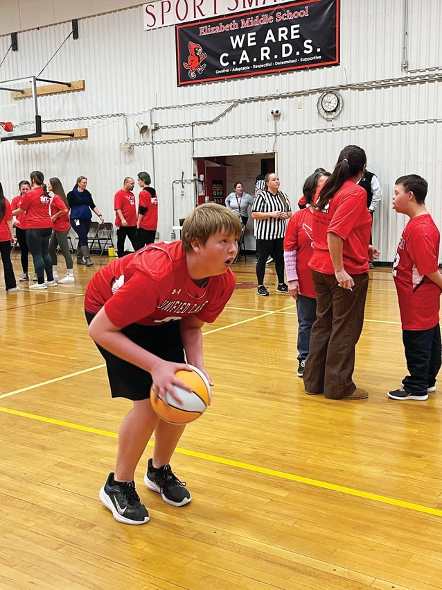A unified basketball player prepares a practice shot before the game.