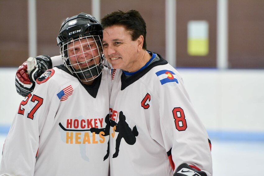 Sarah Karr (left) and Marty Richardson hug on the ice at a Hockey Heals skate on March 22.