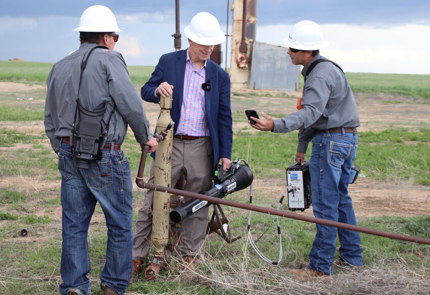 U.S. Sen. John Hickenlooper tries out some of the methane-detecting equipment used by Greenfield Environmental Solutions Chris Rice at an abandoned oil drilling site in unincorporated Adams County.