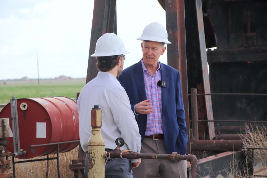U.S. Sen. John Hickenlooper chats with Adam Peltz of the Environmental Defense Fund May 25 at an abandoned oil drilling site in Adams County May 25.