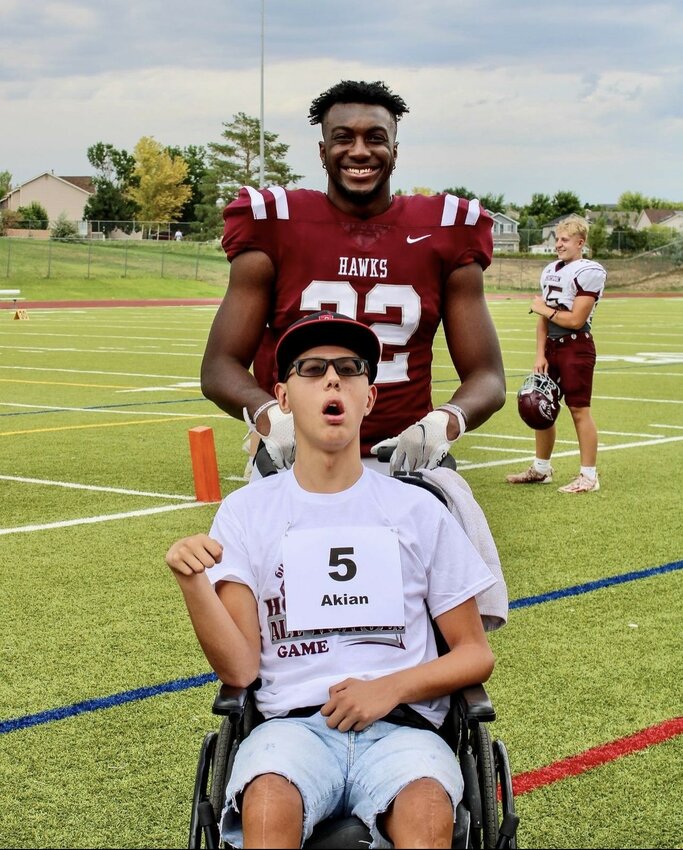 Horizon football's Chase Greene poses with Akian, a participant in last year's event. The players will teach participants drills and lead games against each other.