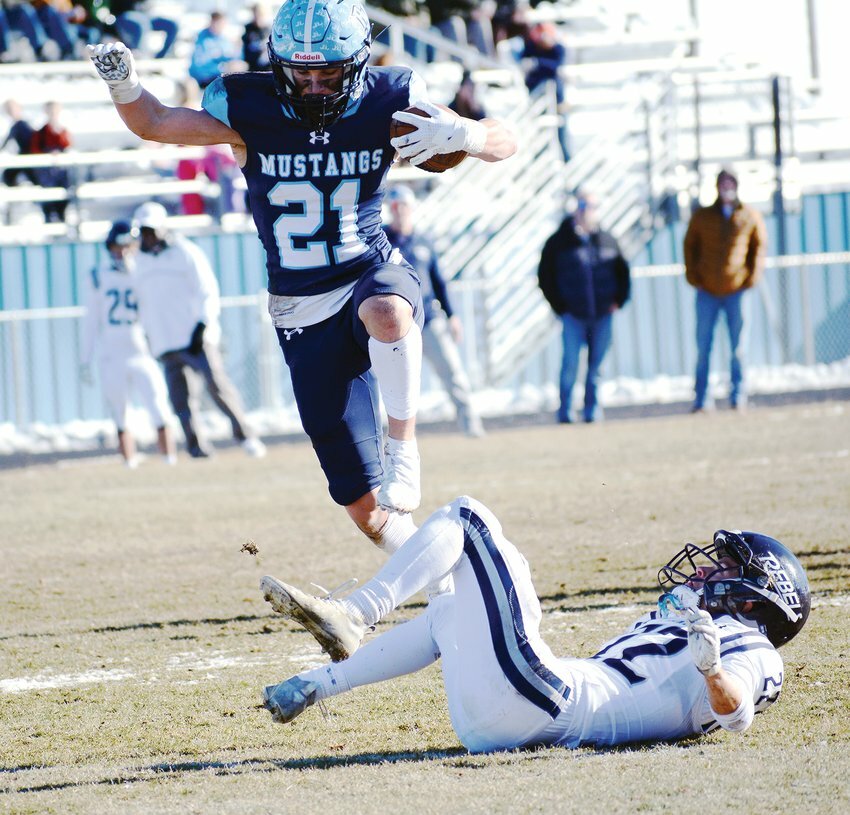 Ralston Valley senior Josh Rillos (21) leaps over Columbine defensive back Cannon Burcar (22) during the Class 5A state quarterfinal game Nov. 19, 2022 at the North Area Athletic Complex. The Mustangs took a 28-7 victory over the Rebels to advance to the state semifinals against No. 2 Valor Christian.