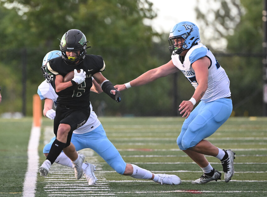 Mountain Vista RB Jack Blais (6) is forced to the sideline by two Ralston Valley defenders.