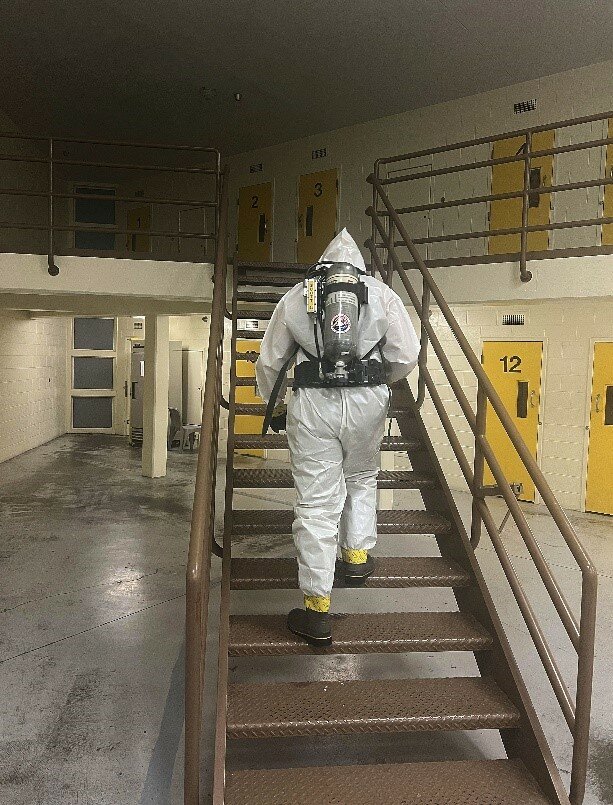 An Adams County Sheriff's deputy, wearing decontamination gear, continues a search for fentanyl in the jail after three inmates overdosed Aug. 22.