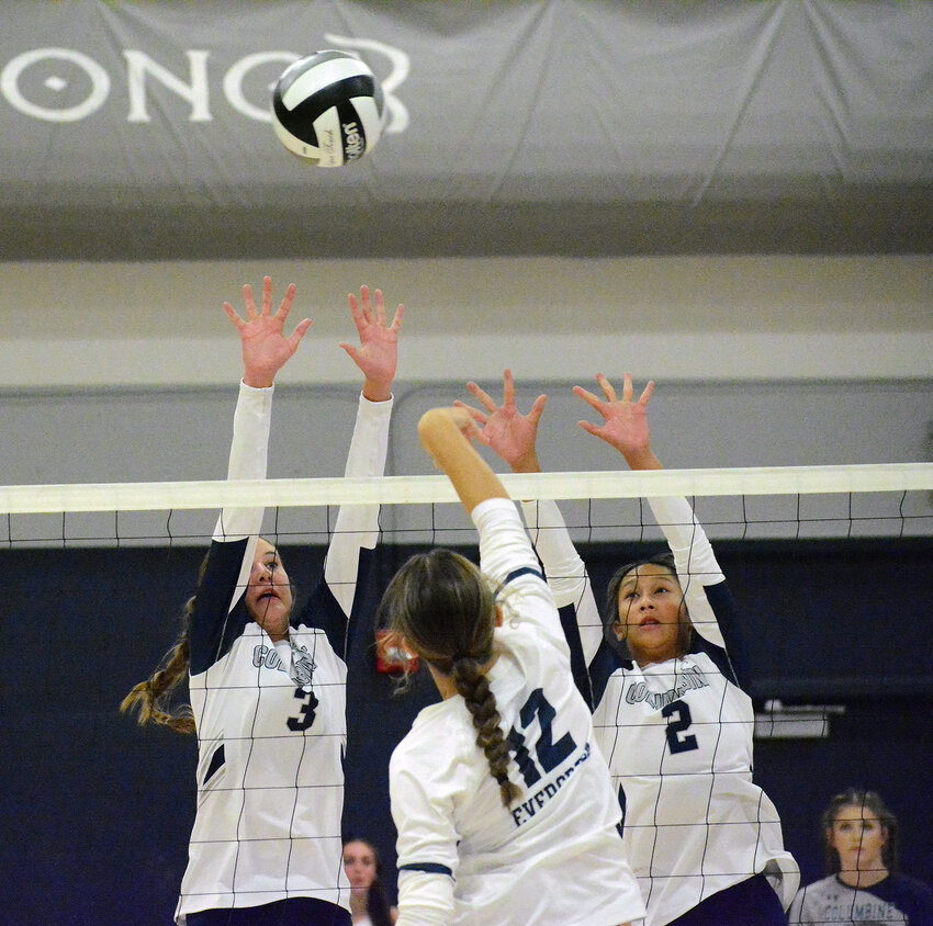 Columbine sophomore Morgan Schneider (3) and senior Aaliyah Rodrakkwan (2) go up for a block on a spike from Evergreen sophomore Mackenzie Carroll (12) during the non-league match Wednesday, Aug. 30, at Columbine High School. The Rebels took a 3-0 victory for their third straight win of the season.