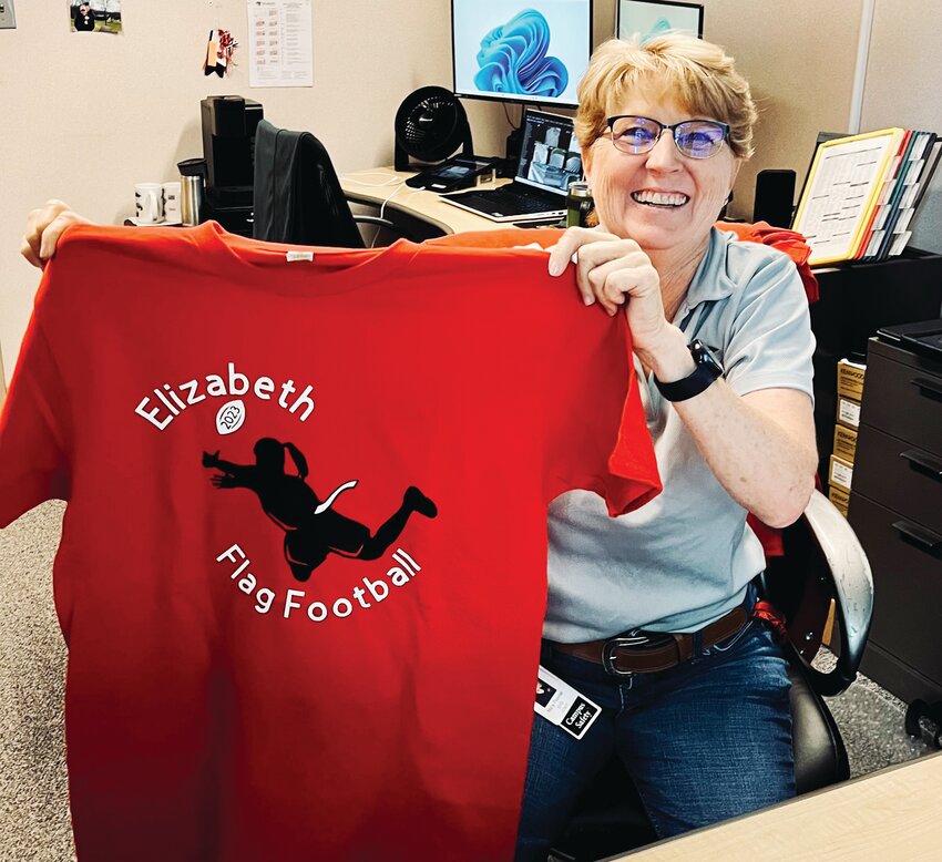 Mary Peavler, EHS Campus Safety, is also grandmother to one of the flag football players. Here she is showing off T-shirts she made for the team.