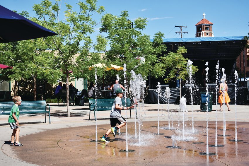 Children run through the fountain in Olde Town Square during the Shindig on Saturday, Sept. 9.
