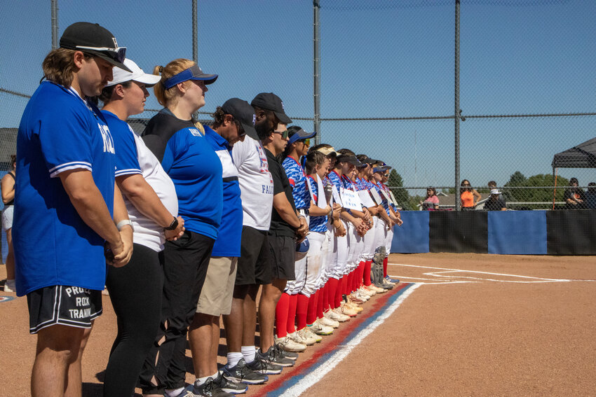 Highlands Ranch softball players and coaches line up during the national anthem before game time.