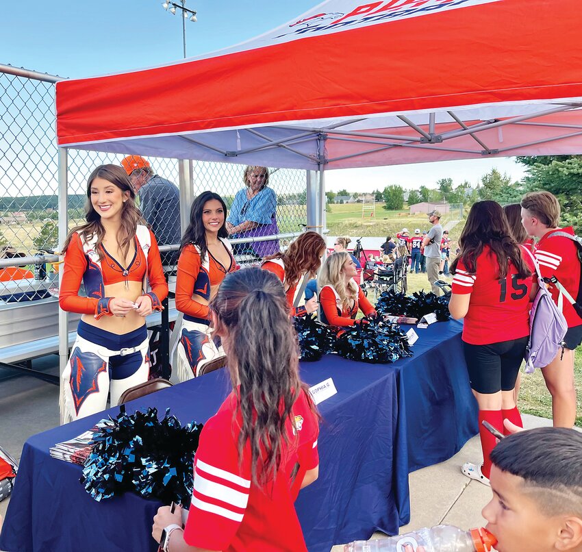 Broncos cheerleaders sign autographs on Sept. 1 at Elizabeth High School during the Denver Broncos High School Home Game of the Week event.