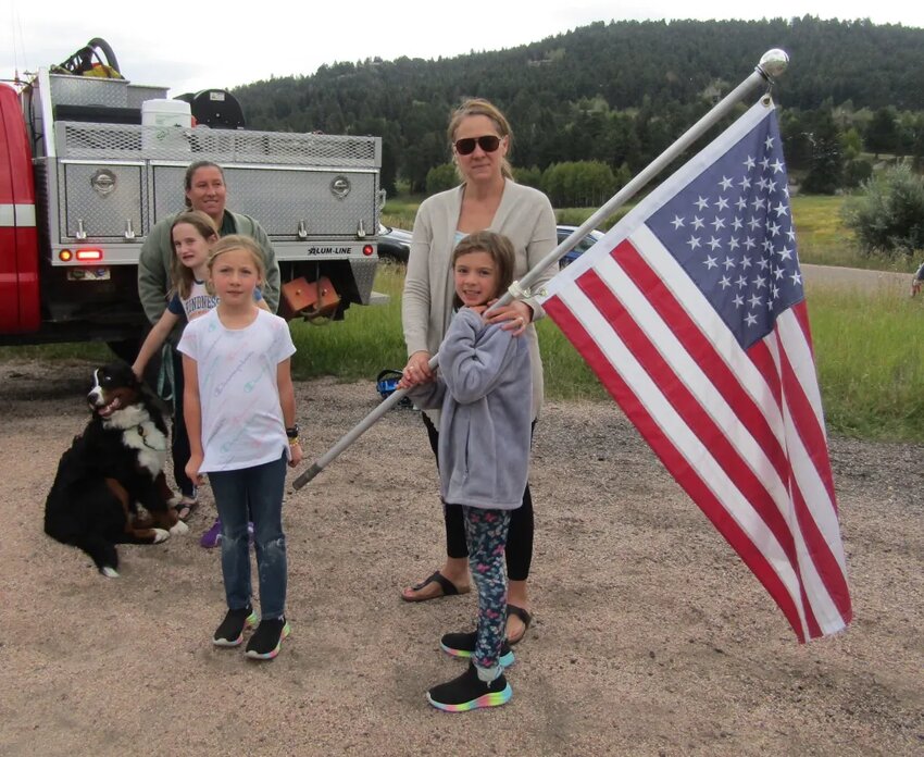 From left, Marni Reinstein, her daughter Kiva and their dog Zakk, Hailey and Anna, and their mom Sarah Davidson wait for the process to go by.