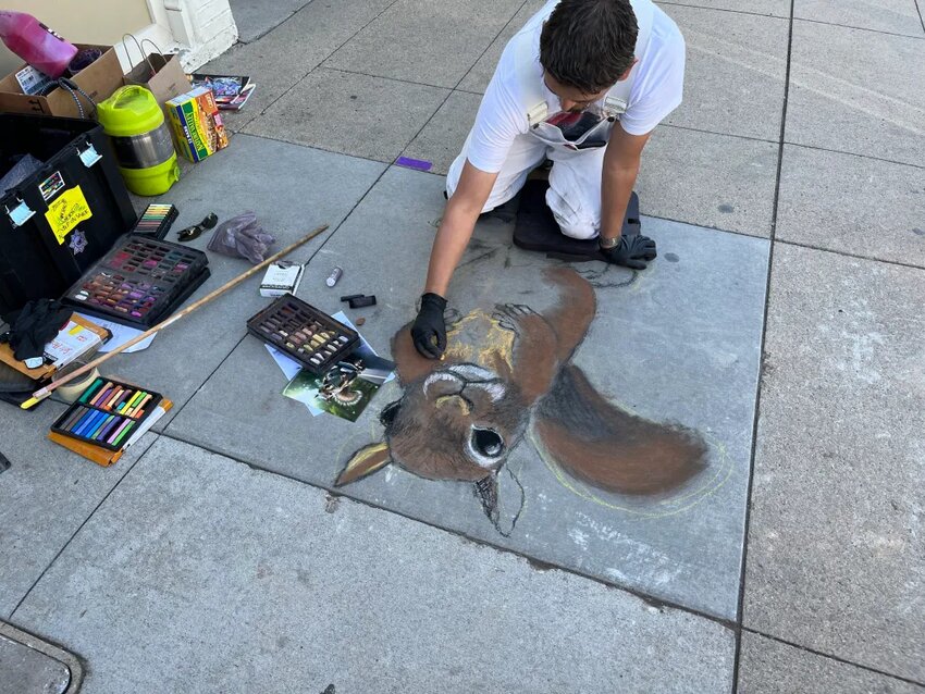 Artist Phillip Bernal creates a realistic squirrel with chalk as his medium at Littleton's Walk the Chalk event. Photo by Kelsey Riley.