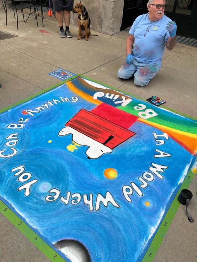 Artist Dan Guerrero drew Snoopy with an inspirational quote at the chalk art festival.