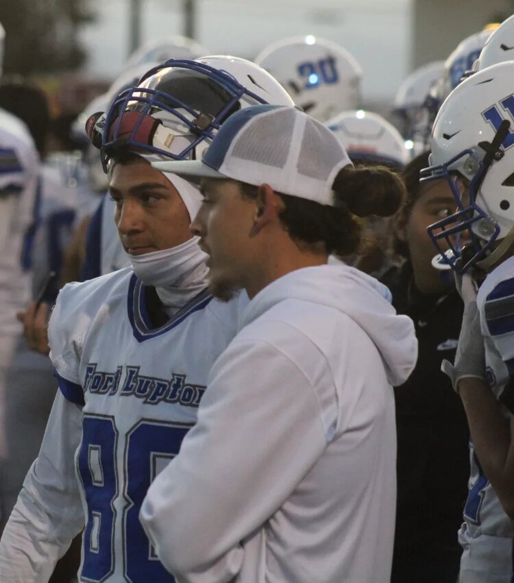 Fort Lupton assistant coach RJ Ramirez, right, and player Tristan LaRue survey the course of play during the Bluedevils’ homecoming win against Valley High School on Sept. 15 / Steve Smith